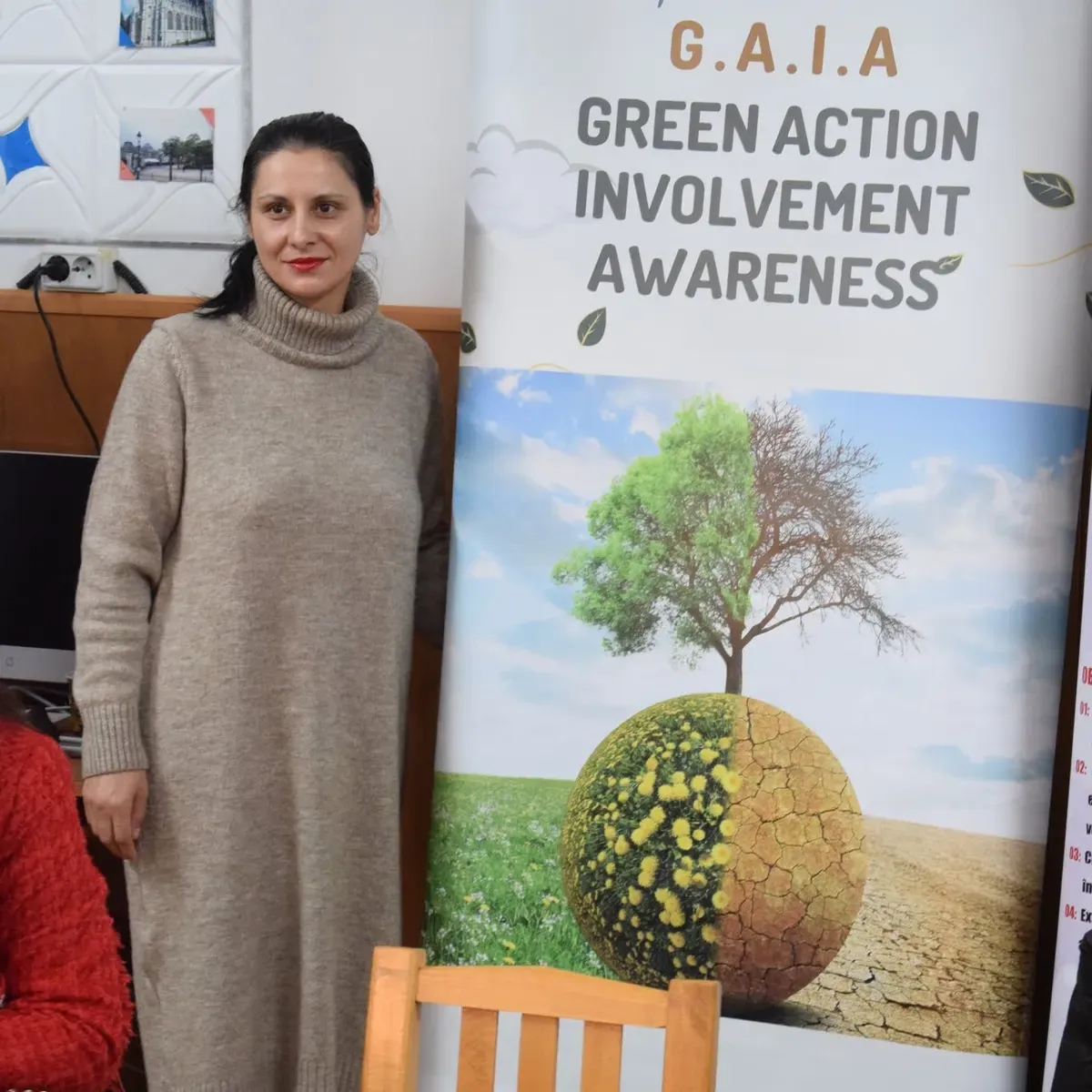 Membră a echipei de proiect lângă roll-up-ul GAIA - Green Action Involvement Awareness