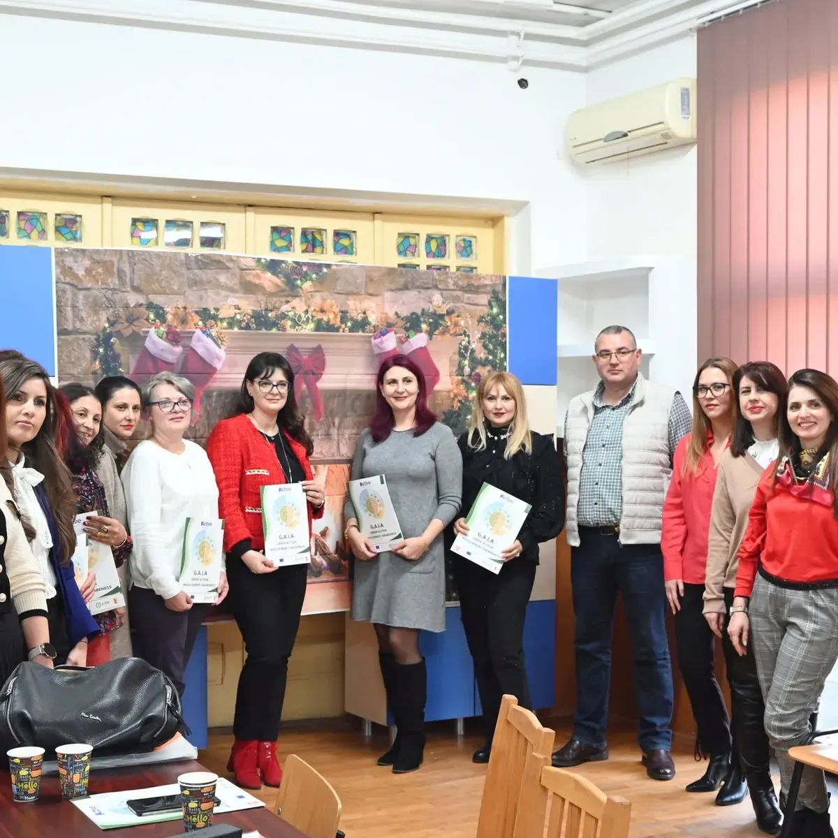 Grup de profesori ținând în mâini mapele GAIA la finalul evenimentului