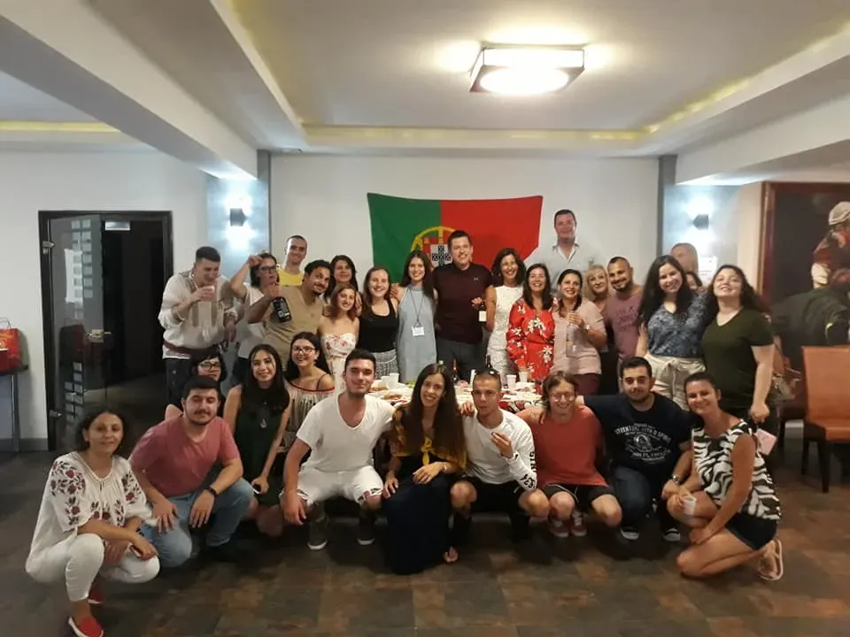 Grupul internațional de participanți, într-o fotografie de grup în fața unui steag al Portugaliei
