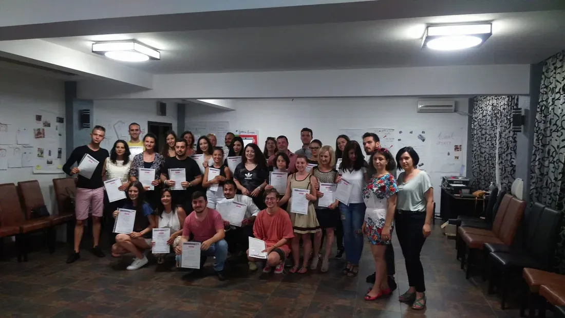 Întregul grup ținând certificatele la finalul formării
